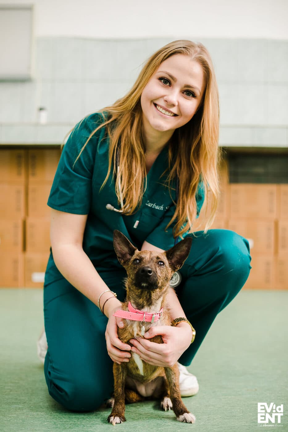 Dr Anne-Catherine Zurbach souriante, accroupie auprès d'un chien